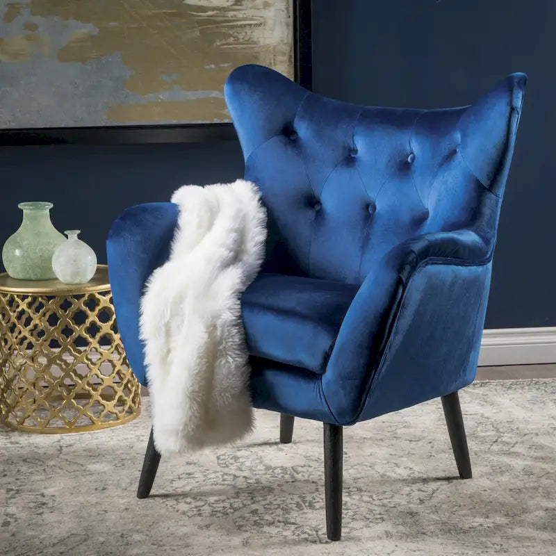 Sillón auxiliar tapizado en terciopelo azul marino con orejeras