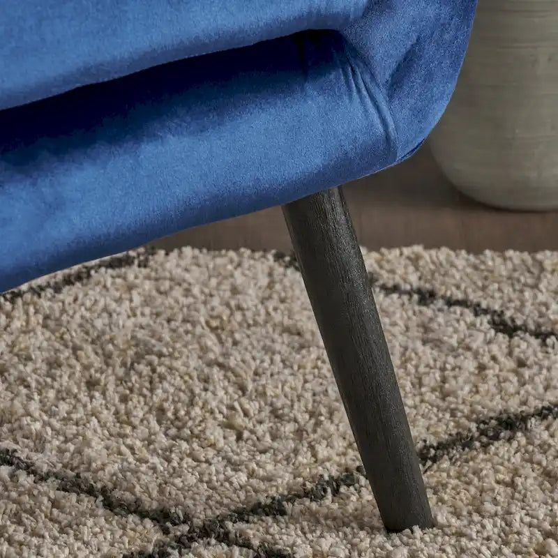 Sillón auxiliar tapizado en terciopelo azul marino con orejeras